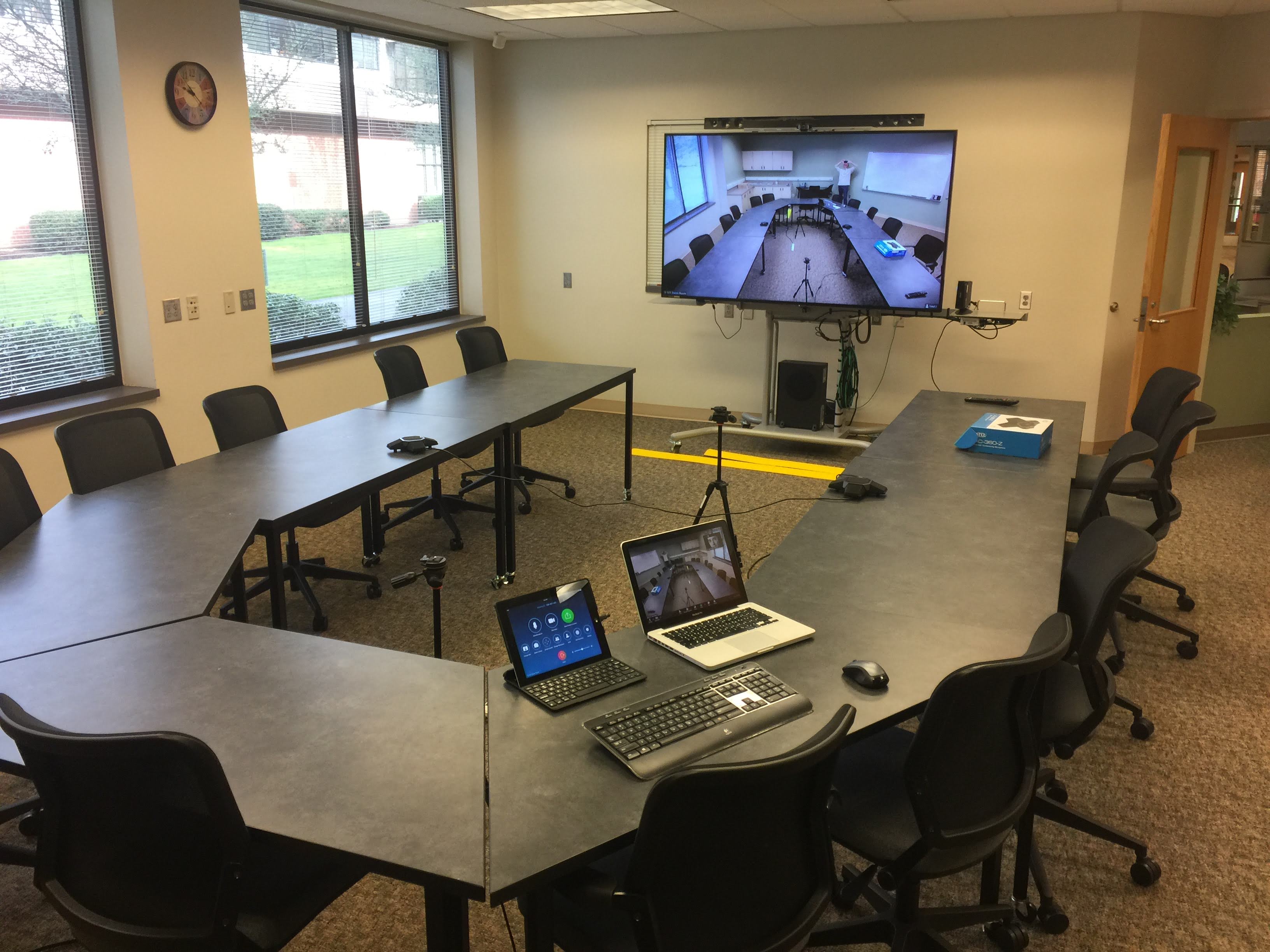Meeting room showing laptop and iPad running a Zoom Room
