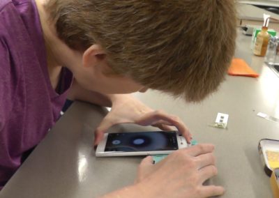 Closeup of Student working with Foldscope on iPhone